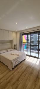 ein Schlafzimmer mit einem großen Bett und einem großen Fenster in der Unterkunft TrevizZo Pense Consolação in São Paulo + 92 Fotos