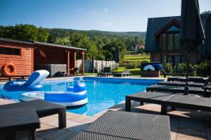 a swimming pool with tables and chairs and a swimming pool at RIVER REST - ADULTS ONLY in Świeradów-Zdrój