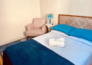 a bedroom with a bed with a chair and towels at Residenciais Maria Flor in Gramado