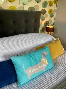 ein Kissen mit einem Hund auf dem Bett in der Unterkunft The BeeKeepers - Homely Luxurious Self Catering in Shelfanger