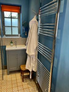 ein Bad mit einem Waschbecken und einem Handtuch in der Unterkunft The BeeKeepers - Homely Luxurious Self Catering in Shelfanger