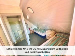 um pequeno quarto com 2 camas num sótão em Mein-Seepark, Ferienhaus Heike em Kirchheim