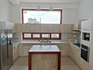 a kitchen with wooden cabinets and a large window at Morona Flats & Pool - 150 m2 in Iquitos