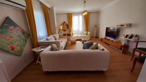 sala de estar con sofá blanco y TV en Şencan House, 
