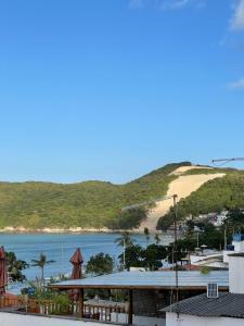 a view of a beach with a hill in the background at Encanto da Praia hotel pousada in Natal
