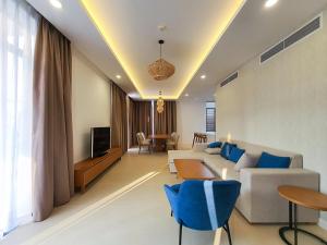 a living room with a white couch and blue chairs at Luxury villa trong Whyndham garden Cam Ranh in Nha Trang