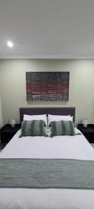 um quarto com uma grande cama branca e 2 almofadas em Uitsig Boutique Hotel em Welkom