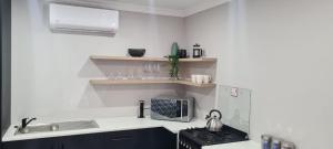 a kitchen with a sink and a stove top oven at Uitsig Boutique Hotel in Welkom