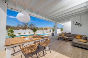 Una sala de estar con mesa y sillas y una piscina. en Luxury Villa Marcos - Private - Large pool, en Noord