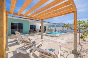 Un patio con sillas y una piscina. en Luxury Villa Marcos - Private - Large pool, en Noord
