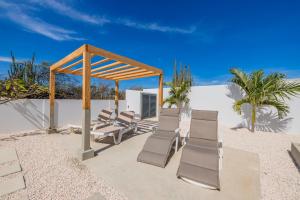 un grupo de sillas y un cenador en la playa en Luxury Villa Marcos - Private - Large pool, en Noord