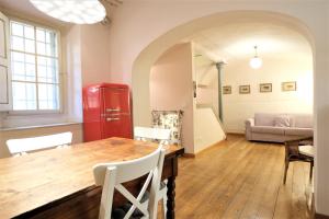 uma sala de estar com uma mesa de madeira e um frigorífico vermelho em Wine Apartments Florence Nebbiolo em Florença