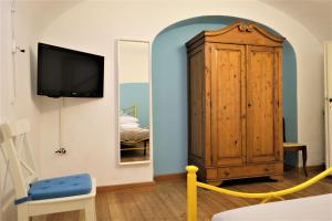um quarto com uma televisão e um armário de madeira em Wine Apartments Florence Nebbiolo em Florença