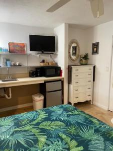 a bedroom with a bed and a desk with a television at Kalama Room in Kailua