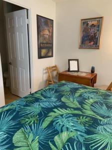 1 dormitorio con 1 cama con manta azul y verde en Kalama Room, en Kailua