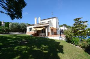 ein Haus mit einem grünen Rasen davor in der Unterkunft ANDORRA 68 in Torroella de Montgrí