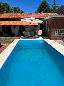 una gran piscina azul frente a una casa en Camunda, en Punta del Este