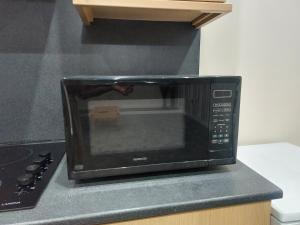 a black microwave on a counter in a kitchen at 2 large bedroom apartment- WIFI & Parking in Fleetwood