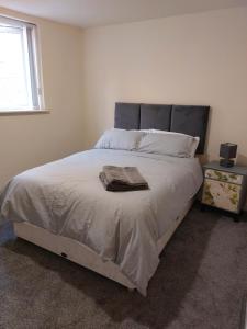 a bedroom with a bed with a blanket and a window at 2 large bedroom apartment- WIFI & Parking in Fleetwood