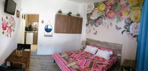 a bedroom with a bed with a flower mural on the wall at M&N Studios in Gabrovo