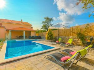 a backyard with a swimming pool with chairs and a fence at House Antonia by IstriaLux in Svetvinčenat