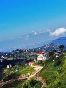a view of a green hill with a building on it at Paradise Villa in Nagarkot