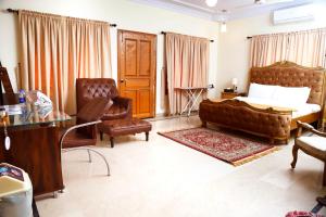 Waypoint Hotel في كراتشي: غرفة نوم بسرير واريكة وكرسي