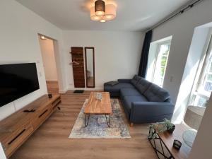 ein Wohnzimmer mit einem blauen Sofa und einem Tisch in der Unterkunft 9011 FeWo Erholung Whg 24 in Lensahn