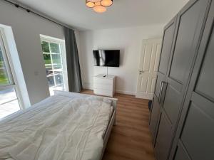 Schlafzimmer mit einem Bett und einem Flachbild-TV in der Unterkunft 9011 FeWo Erholung Whg 24 in Lensahn