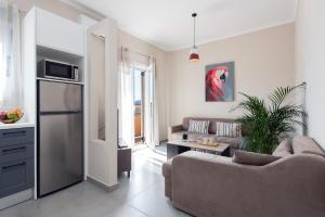 a living room with a couch and a kitchen at Aris by Anita Holiday Homes in Ágios Rókkos