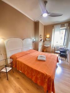 a bedroom with a bed with an orange bedspread at Hotel Dali in Florence