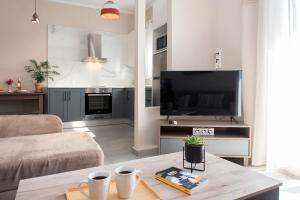 a living room with a large television and a couch at Aris by Anita Holiday Homes in Agios Rokkos