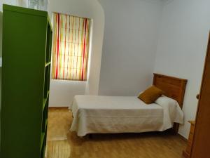 a small bedroom with a bed and a window at San Francisco in Tarifa