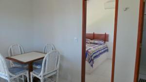 a room with a table and chairs and a bed at Condomínio e Pousada Chalés Sossego do Gostoso in São José