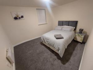 een slaapkamer met een groot bed met witte lakens bij 2 large bedroom apartment- WIFI & Parking in Fleetwood