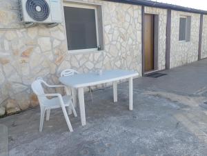 DON BOSCO 2 في باري باليزي: طاولة بيضاء وكرسي بجانب مبنى