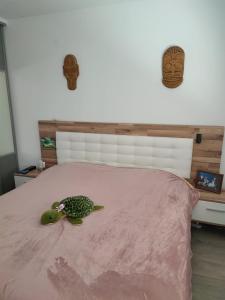 uma cama com uma tartaruga recheada num cobertor rosa em Villa de plain-pied au calme em Mundolsheim