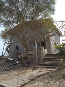 una motocicleta estacionada frente a una casa en Vida Playera en Punta Del Diablo