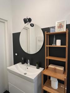 een badkamer met een witte wastafel en een spiegel bij Casa Vito in Trieste