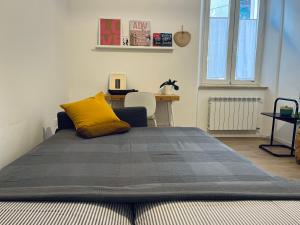 een slaapkamer met een bed met een geel kussen erop bij Casa Vito in Trieste