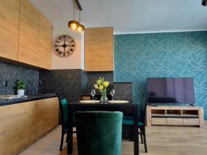 cocina con mesa de comedor con sillas verdes en Parkcity Sokolska en Katowice