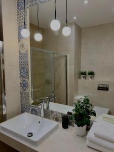 a bathroom with a sink and a shower and a tub at Parkcity Sokolska in Katowice