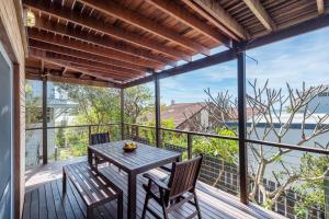 a patio with a table and chairs on a deck at Bimbajong Studio - oceanstays in Yamba