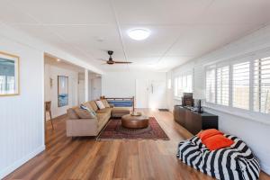 a living room with a couch and a table at Bimbajong Studio - oceanstays in Yamba