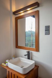 a bathroom with a white sink and a mirror at Dowa Elegance Resort in Ella