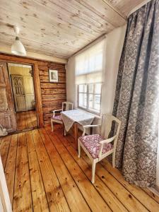 Zimmer mit einem Tisch, Stühlen und einem Fenster in der Unterkunft Juveliera apartamenti in Kuldīga