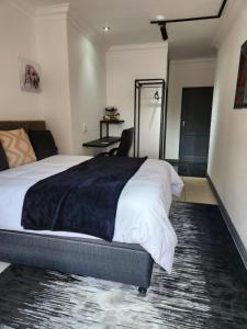 um quarto com uma cama grande e um cobertor preto em 17 On Buffalo em Joanesburgo