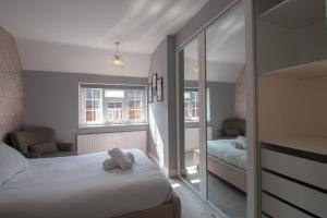 um pequeno quarto com 2 camas e uma janela em 6 Bedroom Holiday Home with Hot Tub & Garden em Luton