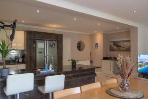 uma cozinha e sala de jantar com mesa e cadeiras brancas em 6 Bedroom Holiday Home with Hot Tub & Garden em Luton