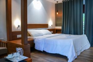 Habitación de hotel con cama y espejo en B'camp Resorts & Homestays en Wayanad